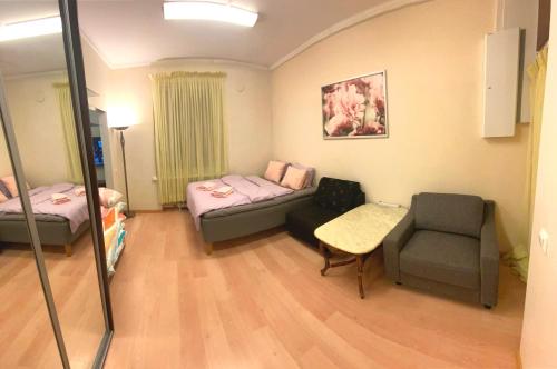 Cette chambre comprend deux lits, un canapé et une chaise. dans l'établissement Center of Helsinki with jacuzzi, à Helsinki