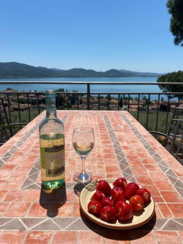 eine Flasche Wein, einen Teller Erdbeeren und ein Glas in der Unterkunft Il Sodino 1738 - Locazione Turistica in San Feliciano