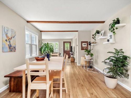 a dining room with a table and some plants at Adorable Wawasee Cottage in Oakwood Park in Syracuse