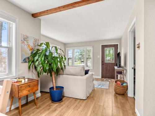 a living room with a white couch and a potted plant at Adorable Wawasee Cottage in Oakwood Park in Syracuse