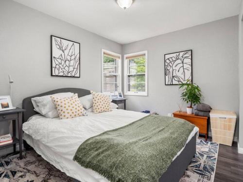 a bedroom with a large bed and two windows at Adorable Wawasee Cottage in Oakwood Park in Syracuse