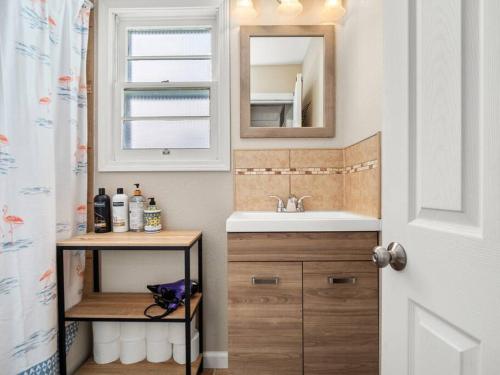 a bathroom with a sink and a mirror at Adorable Wawasee Cottage in Oakwood Park in Syracuse