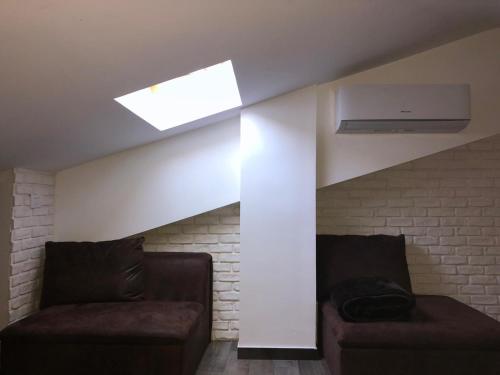 a living room with two chairs and a skylight at Gioconda’s Apartment in Rome