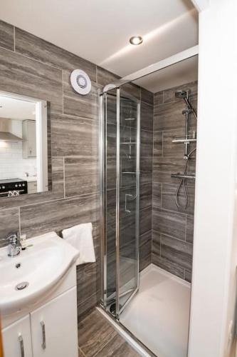 a bathroom with a shower and a sink at Patio lodge with forest access close to beaches in South Wootton