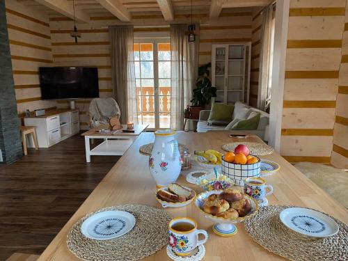 ein Tisch mit Tassen und Teller mit Essen drauf in der Unterkunft Roubenka ARCHA in Dolní Morava