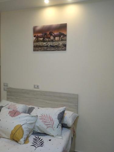 um sofá com almofadas e uma foto de cavalos na parede em كذا بلانكا بيتش 220 em Hurghada