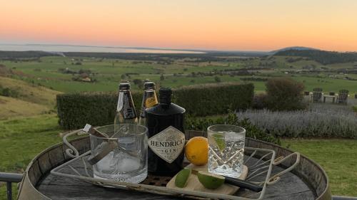 a tray with bottles of wine and glasses on a table at Ocean Willow Gerringong in Gerringong