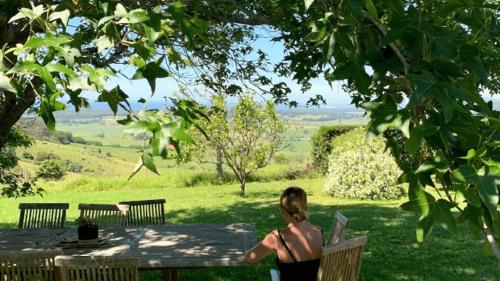 a woman sitting on a bench in the grass at Ocean Willow Gerringong in Gerringong