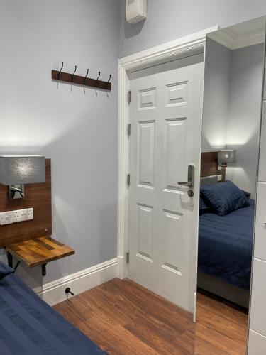 a bedroom with a door and a bed and a desk at Laurieston Inn in Falkirk