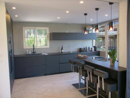 a kitchen with blue cabinets and a black counter at Sublime Villa Piscine Jacuzzi Côte d'Azur in Mouans-Sartoux
