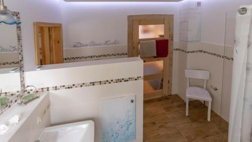ein Bad mit einem Waschbecken und einem Spiegel in der Unterkunft Märchenherberge 7 Zwerge in Hessisch Lichtenau