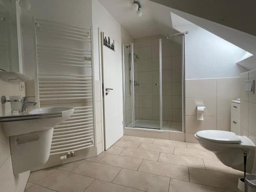 a bathroom with a shower and a sink and a toilet at Ferienwohnung SEEWOLF im Herzen von Zingst in Zingst