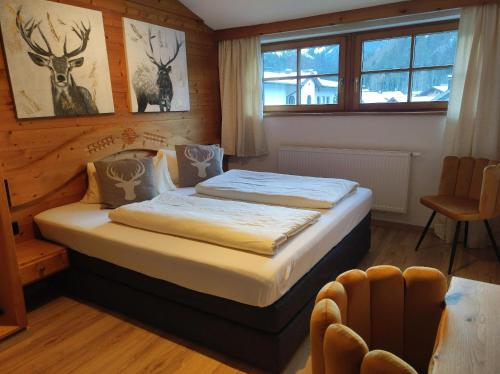 ein Schlafzimmer mit einem Bett in einem Holzzimmer in der Unterkunft Hotel - Landgasthof Post in Bichlbach