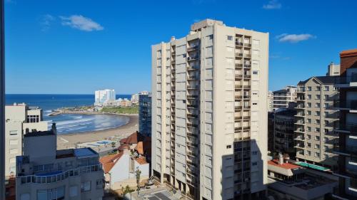 un edificio blanco alto junto a una playa en Departamento Torreón del Monje vista al mar en Mar del Plata