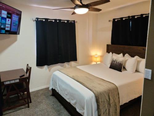 1 dormitorio con 1 cama con ventilador de techo y mesa en 069B Cozy Suite Kitchen & King Bed near South Rim, en Valle