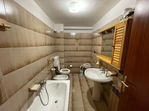 La salle de bains est pourvue de 2 toilettes, d'une baignoire et d'un lavabo. dans l'établissement Rosa Mountain Lake Iseo Hospitality, à Bossico