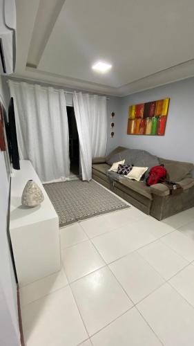 a living room with a bed and a couch at Beach thoow férias in Arraial do Cabo