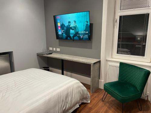 um quarto com uma cama e uma televisão na parede em Laurieston Inn 