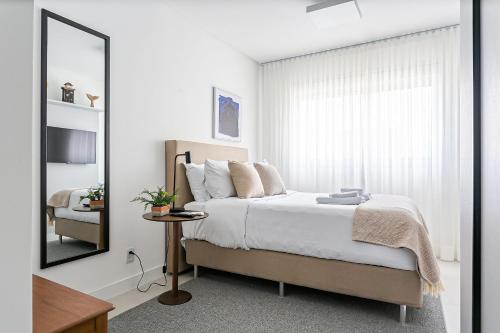 1 dormitorio con 1 cama grande y espejo en WI-FI 400MB | 500m do mar | Churrasqueira #IA11, en Florianópolis