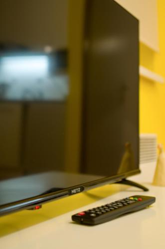 a computer monitor and a remote control sitting on a desk at Apartmán Orbit in Malá Morávka