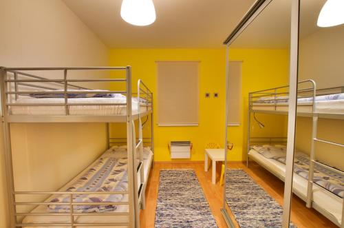 a room with three bunk beds and yellow walls at Apartmán Orbit in Malá Morávka