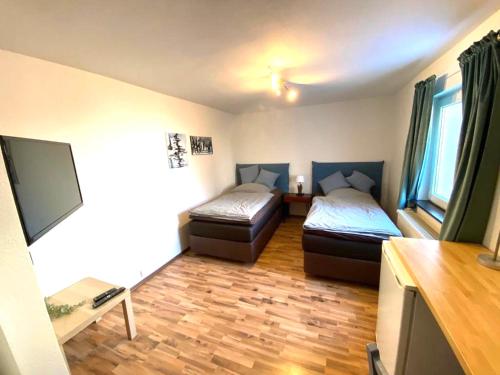 Zimmer mit 2 Betten und einem Flachbild-TV in der Unterkunft Wohnzeit-Köln in Köln