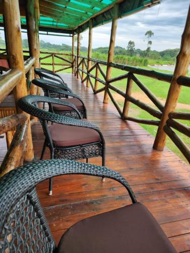a group of chairs sitting on a wooden deck at Ishasha Pride Lodge in Kihihi