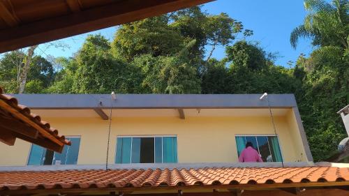 a woman standing in the window of a house at Residencial Di Paoli in Bombinhas