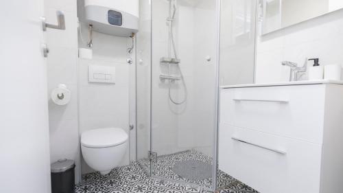 ein weißes Badezimmer mit Dusche und Toilette in der Unterkunft Apartment miTski Kop in Kopaonik