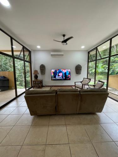 a large couch in a living room with a flat screen tv at Private 5 Bedroom Home with Pool! in Tarcoles