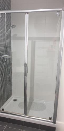 y baño con ducha y puerta de cristal. en Appartement T2 45 m² en centre-ville, en Ax-les-Thermes