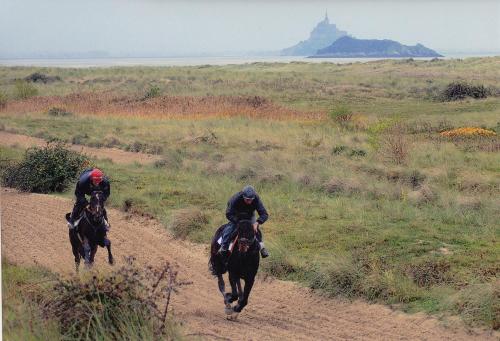 two people riding horses down a dirt road at Le Domaine de Belleville in Dragey