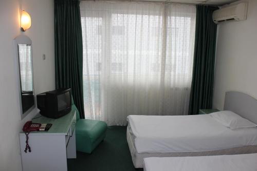 Ένα ή περισσότερα κρεβάτια σε δωμάτιο στο Rodopi Hotel