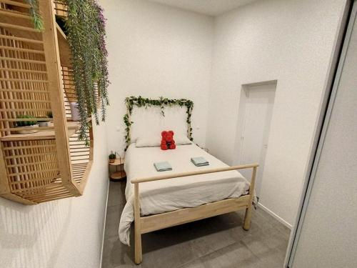 a small bedroom with a teddy bear sitting on a bed at SPA JUNGLE in Le Mesnil-Saint-Denis