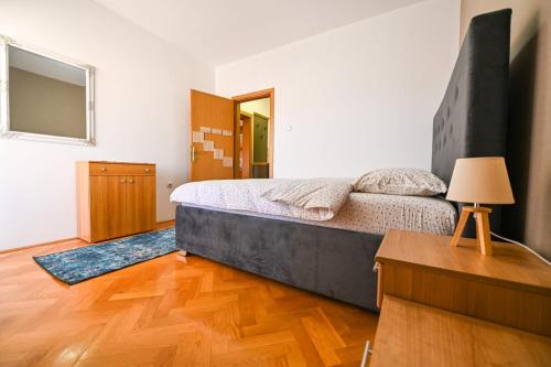 Schlafzimmer mit einem Bett, einem Tisch und einem Spiegel in der Unterkunft Norandvik Apartment in Podgorica