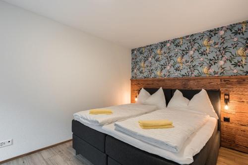 a bedroom with a bed with two yellow towels on it at Melchtal Resort Apart Hotel in Melchtal