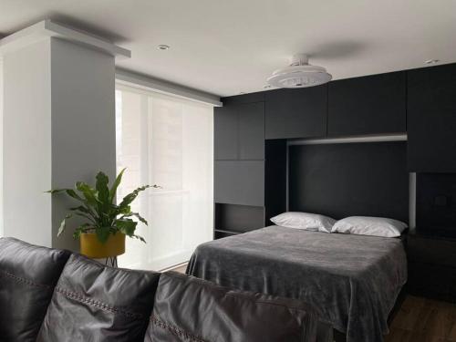 1 dormitorio con cama y sofá de cuero en Black Loft. Moderno y nuevo, súper ubicado., en Ciudad de México