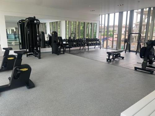 un gimnasio con filas de máquinas de correr y un espejo en The Lennox suite Airport residential Area en Accra