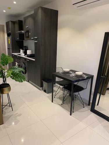 a kitchen with a black table and chairs in a room at The Lennox suite Airport residential Area in Accra