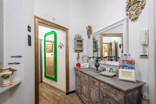 a bathroom with a vanity with a green framed mirror at Le Stanze del Principe in Genova