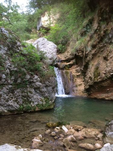 a waterfall in a canyon with a pool of water at Mymoustiers in Moustiers-Sainte-Marie