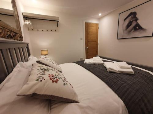 a bedroom with a large bed with two pillows at Luton Town Centre Executive Apartment in Luton