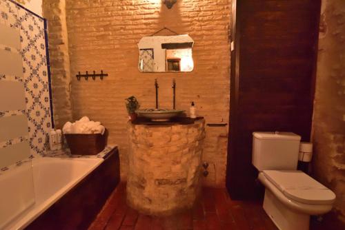 een badkamer met een wastafel, een toilet en een bad bij Casa Tenorio Barrio de Santa Cruz in Sevilla