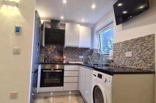 a kitchen with a washer and dryer in it at THE ONE- luton 1 bed, free parking in Luton