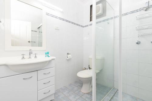 La salle de bains blanche est pourvue d'une douche et de toilettes. dans l'établissement Forster Holiday Lodge 18, à Forster