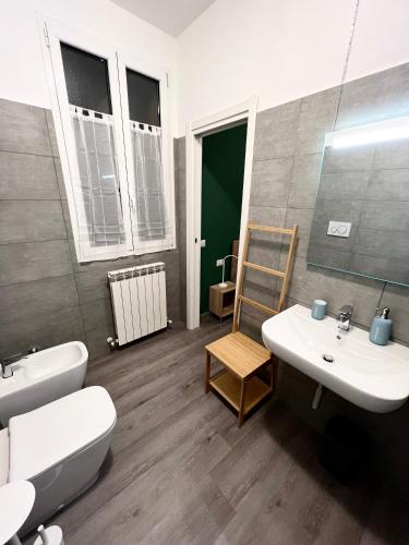 a bathroom with a sink and a toilet and a mirror at La Casa di Ricky in Seregno