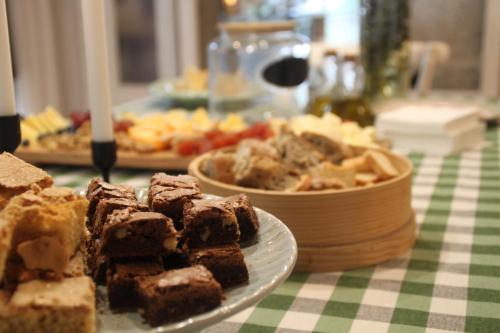 a table with a plate of brownies and a bowl of food at Hotel a Ecogranxa in Pontevedra