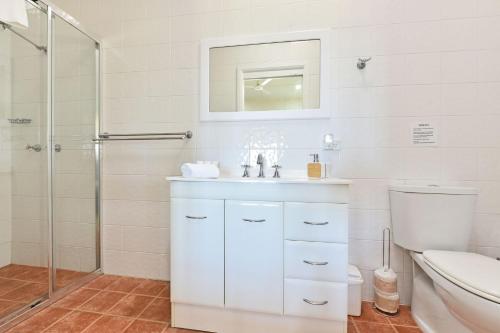 y baño blanco con lavabo y ducha. en Brokenback Vineyard Cottage, en Pokolbin