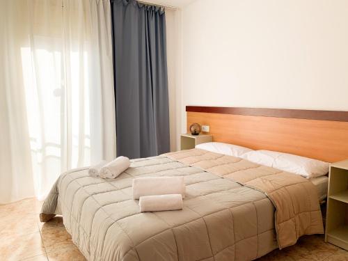 ein Schlafzimmer mit einem großen Bett mit zwei Handtüchern darauf in der Unterkunft Apartamentos OlaMar in Lloret de Mar