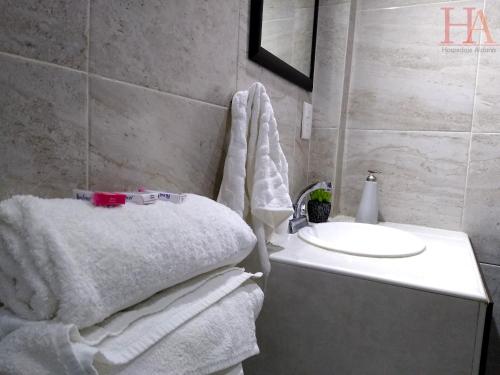 a bathroom with white towels and a sink at Hospedaje Aldana - Habitación ACUA zona centro in Tuxpan de Rodríguez Cano